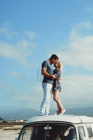 Téléchargez les photos : Love and travel concept lifestyle emotion with young traveler people couple standing and kissing on the roof of a classic van camper. Transport and alternative life off grid. Road trip vacation view - en image libre de droit