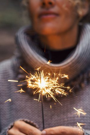 Photo for Close up of woman people holding sparkler and celebrate outdoor. New year eve and christmas celebration concept. Happiness and serene female person. Hope and future. One lady celebration. Fireworks - Royalty Free Image