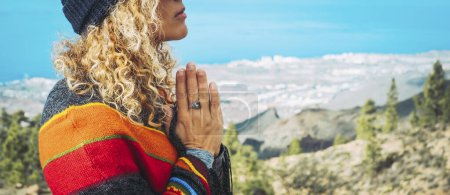 Photo for Close-up of calm young Caucasian woman holding hands on heart chest and feeling grateful and grateful. Happy female shows gratitude, love and care, prays or displays. Religion, faith concept. - Royalty Free Image