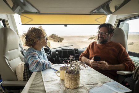 Téléchargez les photos : Couple profite du week-end à bord de leur camping-car. Homme heureux avec sa femme passer des moments agréables. Concept de liberté et de temps libre - en image libre de droit