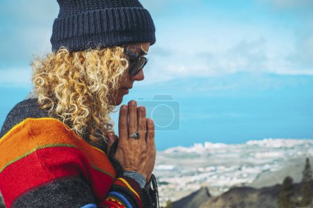 Photo for Close-up of calm young Caucasian woman holding hands on heart chest and feeling grateful and grateful. Happy female shows gratitude, love and care, prays or displays. Religion, faith concept. - Royalty Free Image