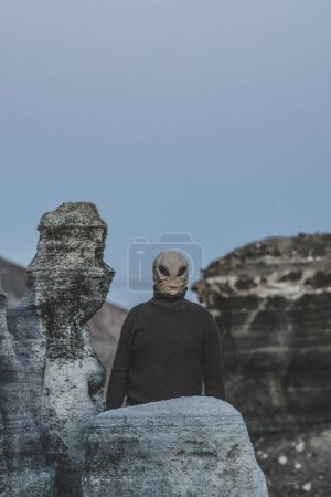 Photo for Standing alien mask people in moon style landscape. Concept of diversity and alien invasion. Portrait of extraterrestrial life. One ufo standing and looking around. Blue mood night color - Royalty Free Image