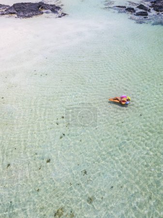 Téléchargez les photos : Femme profiter de la plage et des vacances d'été détente reposer sur une lilo colorée dans l'eau de mer transparente - les gens aiment Voyage et concept de style de vie - en image libre de droit