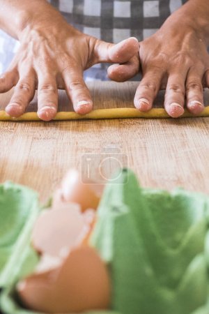 Photo for Close up of woman at home preparing and cooking hand made pasta on the table - concept of work indoor house activity for wife or single female - healthy food nutrition cake pie lunch - Royalty Free Image