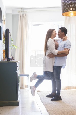 Téléchargez les photos : Pleine longueur de jeune couple insouciant dansant à la maison ensemble - en image libre de droit