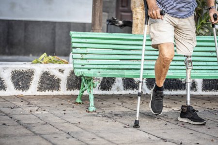 elderly man with a titanium prosthetic left leg walks smoothly in a city park