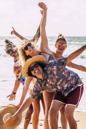 Foto de Grupo de jóvenes caucásicos felices niños y niñas se divierten y disfrutan de la playa en vacaciones de verano juntos riendo - Imagen libre de derechos