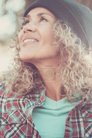 Téléchargez les photos : Bonheur dans l'expression portrait d'une femme attirante adulte profitant d'activités de loisirs de plein air avec forêt en arrière-plan. - en image libre de droit
