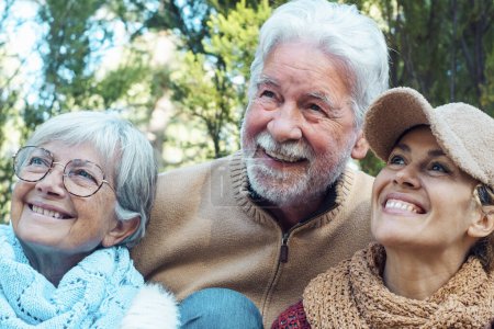 Photo for Caucasian family portrait smile and hug with nature trees forest background. Adult and mature retired people enjoying leisure activity outdoors together. Concept of mountains holiday vacation - Royalty Free Image