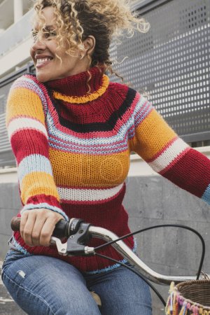 Photo for Happy mature  woman riding a bike and smiling enjoying outdoor active healthy leisure activity. Green ambient and environment way of transport with female people using bicycle - Royalty Free Image