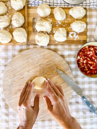Photo for Top view of woman preparing handmade lunch like bread or pizza in traditional work at home on table in the kitchen. Unrecognizable person prepare fresh bakery with hands. Fresh raw ingredients work - Royalty Free Image