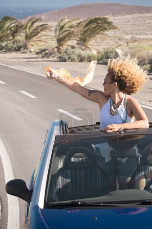 Foto de Viajes en coche amigos transporte dos mujeres felices disfrutan de auto convertible juntos en vacaciones de verano viaje - océano y playa en el fondo - conducción y divertirse concepto - Imagen libre de derechos