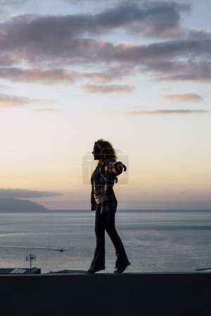 Photo for Concept of success and happiness for free people - freedom happy woman walk in balance with amazing ocean nature view in background - tourist and tourism in holiday vacation - Royalty Free Image