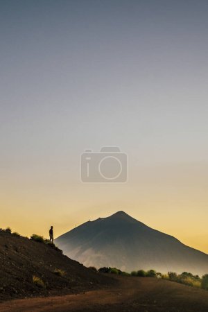 Téléchargez les photos : Wanderlust and travel people lifestyle concept with standing man enjoy adventure and explore beauty of the world - mount volcano el teide, tenerife in background - concept of trekking and hiking activity - en image libre de droit