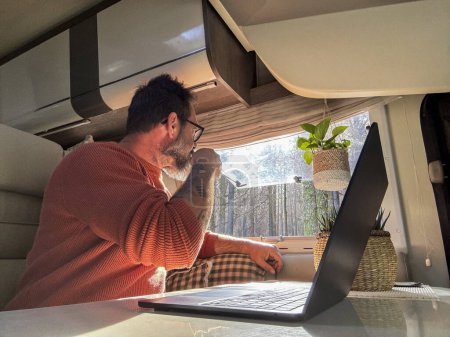 Photo for Digital nomad working inside a camper van travel lifestyle vehicle vanlife using laptop computer and roaming internet connection. People and telecommuting remote worker. Life in motorhome. Modern - Royalty Free Image