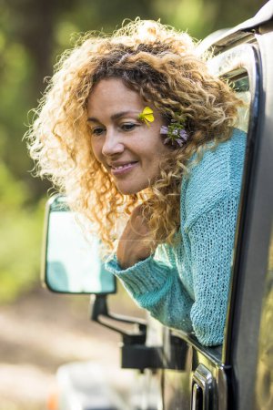 Foto de Hermoso concepto de viaje mujer adulta disfrutar del bosque sentarse dentro de un coche y fuera de la ventana aventura y naturaleza alternativa amor estilo de vida para la gente feliz en la actividad de vehículos de ocio al aire libre - Imagen libre de derechos