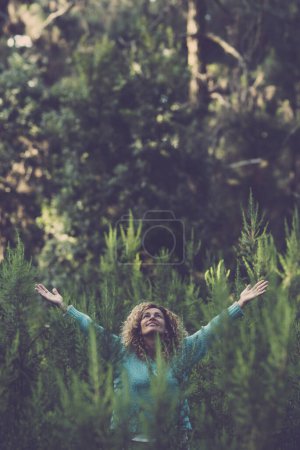 Téléchargez les photos : Gens heureux femme heureuse au milieu de la forêt de bois avec des arbres et des plantes partout autour - sauver et respecter la nature aucune activité commerciale de déforestation - journée de célébration de l'événement de la terre - en image libre de droit