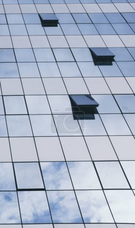 Foto de Vista de las ventanas azules en un rascacielos moderno edificio de oficinas - concepto de personas en el trabajo en la vida - ventanas abiertas y cerradas con reflejo del cielo - Imagen libre de derechos