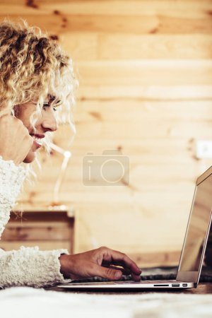 Photo for Beautiful happy caucasian adult woman work on a personal laptop computer at home or hotel room - modern digital nomad lifestyle and people free from office with technology - Royalty Free Image