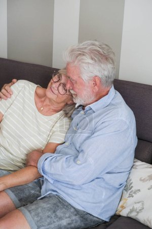 Photo for Mature couple at home. Senior man hugging and care aged woman. Having care. Living together elderly lifestyle people in indoor leisure activity having relax and relationship. Romantic scene with old - Royalty Free Image