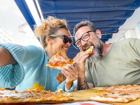 Photo for Smiling couple enjoy lunch at pizzeria. Beautiful smiling couple taking selfie and having fun in pizza, having fun together. Consumerism, food, lifestyle concept - Royalty Free Image