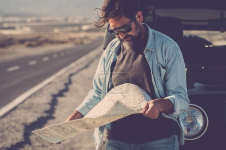 Photo for Travel and adventure people with vehicle concept lifestyle.  man standing outside the off-road car and reading a paper guide map to find the roads and destination. Travel and lost. Tourist trip - Royalty Free Image