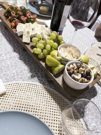 Foto de Plato con diferentes tipos de queso y vino en la mesa - Imagen libre de derechos
