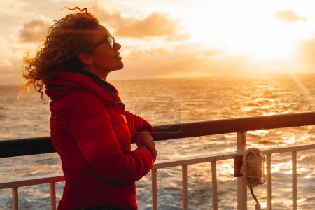 Téléchargez les photos : Les gens aiment voyager et vivre des aventures. femme sur ferry bateau profiter coucher de soleil couleur soleil souriant et relaxant. Touriste sur le transport maritime. Vacances d'été. Surface de la mer. - en image libre de droit
