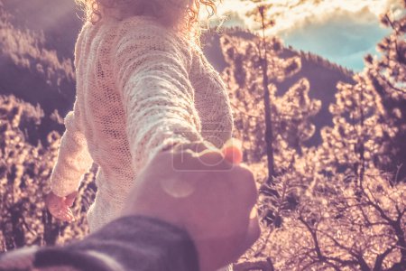 Téléchargez les photos : Femme adulte tenir la main de son petit ami et profiter du coucher de soleil à la montagne dans la randonnée de loisirs de plein air - les gens dans la nature s'amusent ensemble - vacances alternatives - en image libre de droit