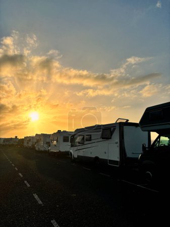 Photo for Many camper vans motorhome vehicle parking on the road with amazing sunny sunrise sunset view. Alternative travel and vacation holiday concept vanlife lifestyle. Journey with modern recreational van - Royalty Free Image