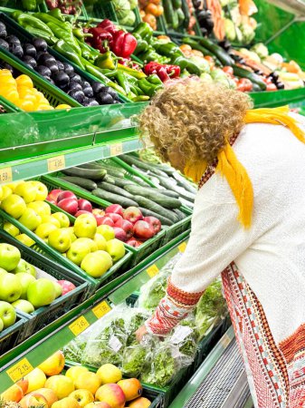 Foto de Hermosa mujer de compras de frutas y verduras en el departamento de productos de una tienda de comestibles / supermercado (color tonificado imagen) - Imagen libre de derechos