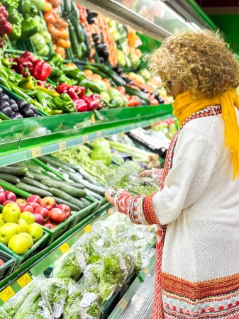 Téléchargez les photos : Belle femme faisant du shopping pour les fruits et légumes dans le département des produits d'une épicerie / supermarché (image tonique de couleur) - en image libre de droit
