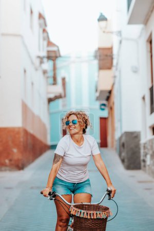 Photo for Bike, attractive and happy woman on vacation smiles examining architecture. Female riding bicycle in summer. Eco-friendly transport to reduce the carbon footprint of women who cycle - Royalty Free Image