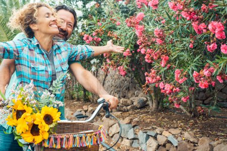 Photo for Happy couple spend happy time enjoying spring. Newlyweds together on a bike play and laugh. Concept of love and leisure - Royalty Free Image
