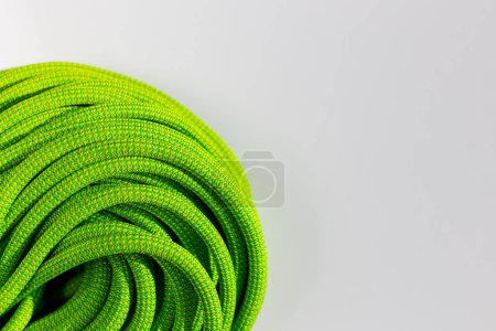 Photo for Green rope for rock climbing and mountaineering lies on a white background. background image of rope for active sports. sports equipment. - Royalty Free Image