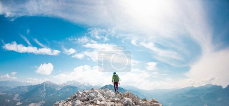Téléchargez les photos : Grimpeur se tient au sommet de la montagne. fille grimpeuse dans un casque et avec un sac à dos montagnes. le concept d'aventure et de randonnée en montagne. Turquie. - en image libre de droit
