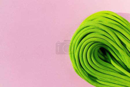 Photo for Green rope for rock climbing and mountaineering lies on a colored background. background image of rope for active sports. sports equipment. - Royalty Free Image