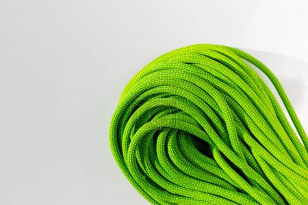 Photo for Green rope for rock climbing and mountaineering lies on a white background. background image of rope for active sports. sports equipment. - Royalty Free Image