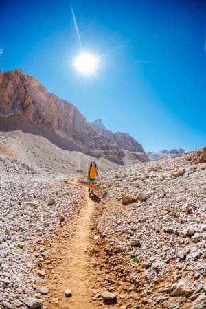Kind reist mit Rucksack in die Berge. Bergwanderung im Hochgebirge. Der Junge läuft auf einem Bergpfad. Türkei.