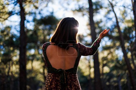 Portrait of a young beautiful dancer practicing intently among natural landscapes. A young and beautiful girl dances and sings in the forest among the trees. girl alone with nature.
