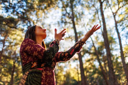 joven y hermosa bailarina practicando intensamente entre paisajes naturales. Una joven y hermosa niña baila y canta en el bosque entre los árboles. chica sola con la naturaleza.