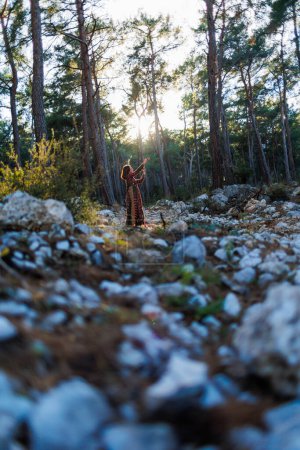 jeune belle femme marche à travers la forêt dans une belle robe. Concept d'équilibre, d'harmonie et de santé. fille seule avec la nature.