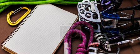 Notebook and climbing equipment Preparing for a trip. Carabiner and rope.