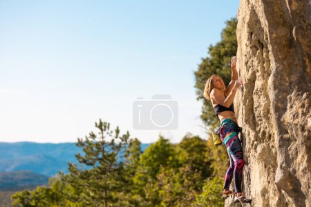 Das Mädchen klettert den Felsen hinauf. Der Kletterer trainiert auf natürlichem Terrain. Extremsport. Aktivitäten im Freien. Eine Frau überwindet eine schwierige Kletterroute im kroatischen Kompan