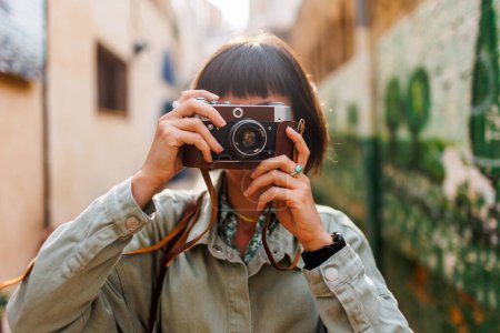 Fotografin mit Kamera fotografiert im Freien. Schöne Frau macht Fotos im Freien mit einer analogen Kamera. Reisen in arabische Länder. Reisen und Urlaub.