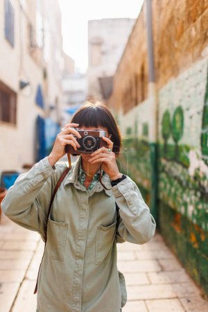 Beautiful woman takes pictures outdoors using an analog camera. travel to Arab countries. travel and vacation.