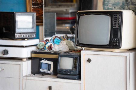 Foto de Televisores viejos y otras cosas viejas en una tienda de chatarra - Imagen libre de derechos