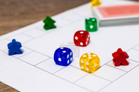 Close-up of a board game with colorful pieces and dice on a grid playfield.