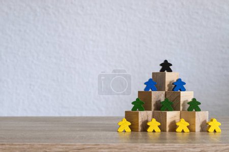 Wooden blocks arranged in a pyramid with colorful figures placed strategically.