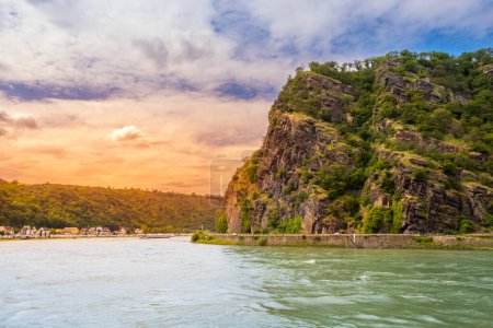 Lorelei rock at sunset. Bank of Rhine river near Sankt Goarshausen town in Rhineland-Palatinate, Germany. Landscape of River Rhein and famous Loreley mountain in Rhine Gorge.